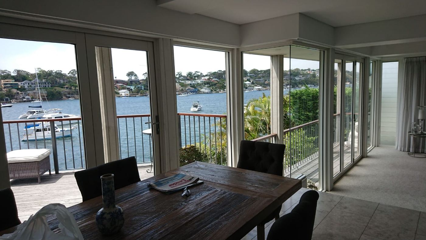 Dining room with a wall of clean glass doors overlooking the water