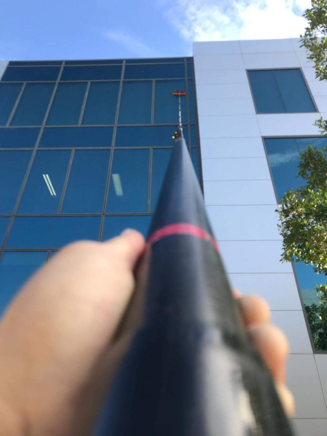 Extension pole reaching high windows on an office building